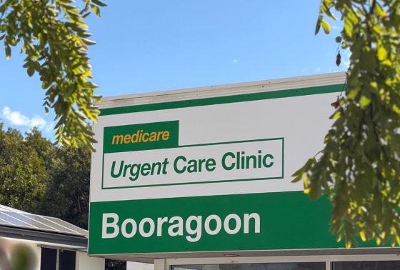Booragoon Medicare Urgent Care Clinic sign in green and white with tree branches framing the sign