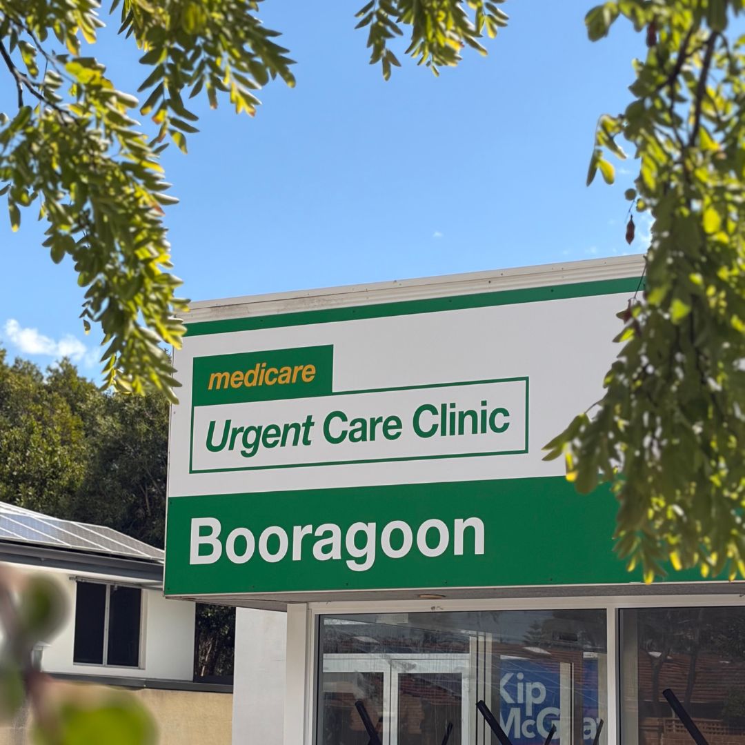 Booragoon Medicare Urgent Care Clinic sign in green and white with tree branches framing the sign