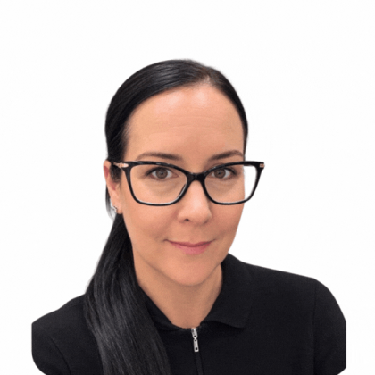 Sarah smiles at the camera, she has dark hair. she is wearing black glasses and a black top.